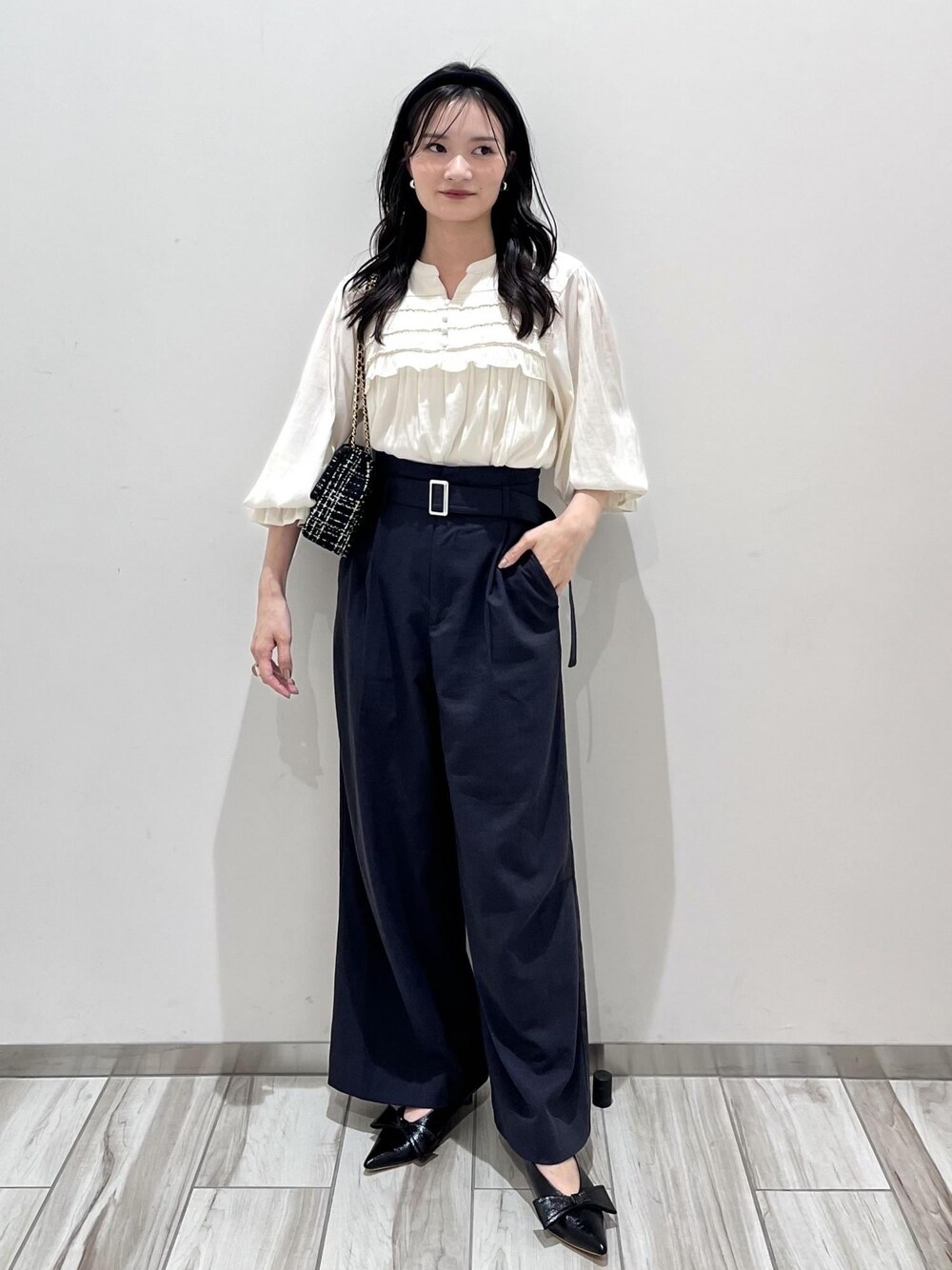 ブラック系のパンプス、ブラック系のショルダーバッグ、ホワイト系のシャツ/ブラウスを着用したレディースの秋コーディネートの1枚目の写真