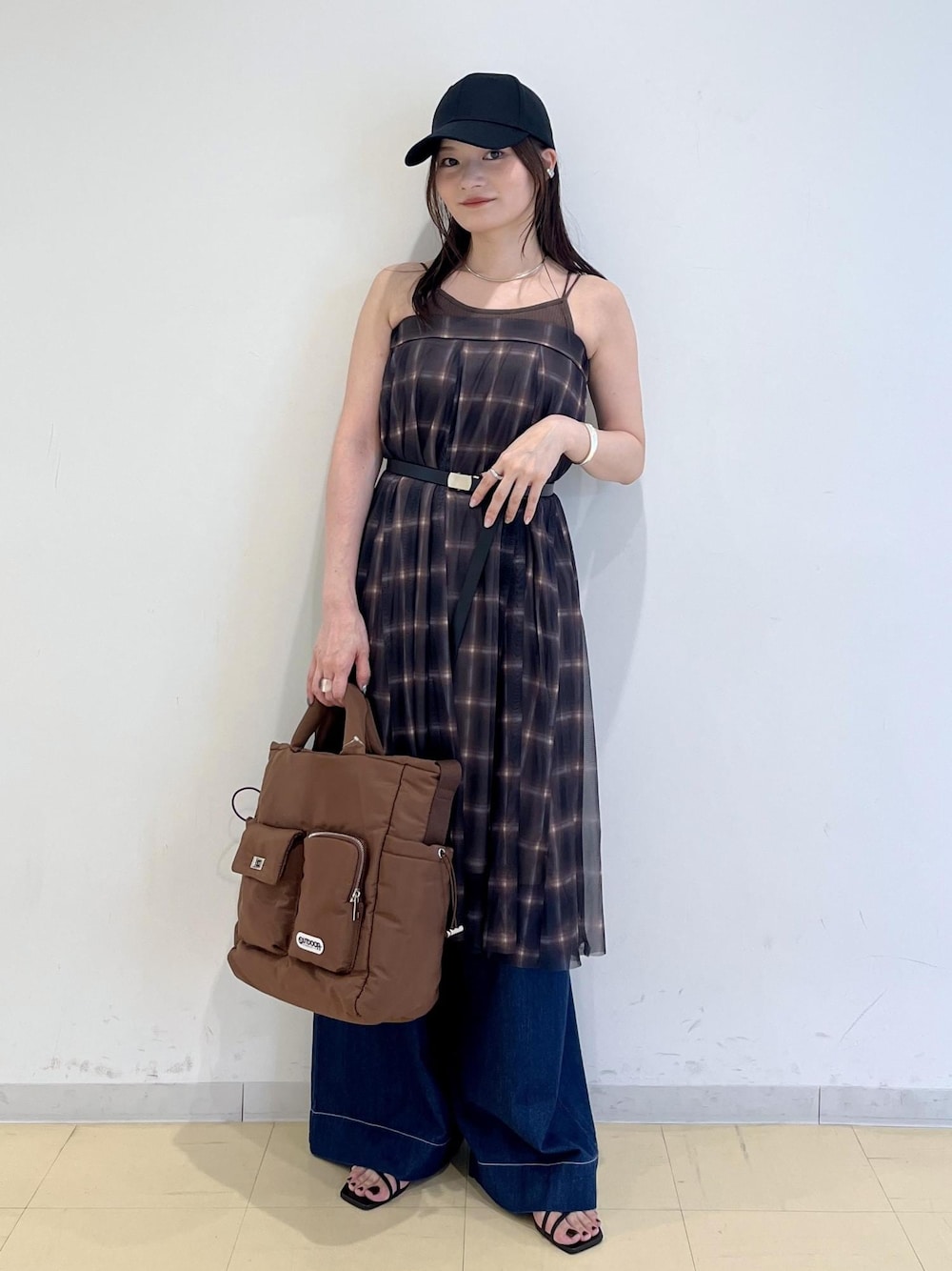 ブルー系のデニムパンツ、ブラウン系のスカート、ブラウン系のキャミソールを着用したレディースの夏コーディネートの1枚目の写真