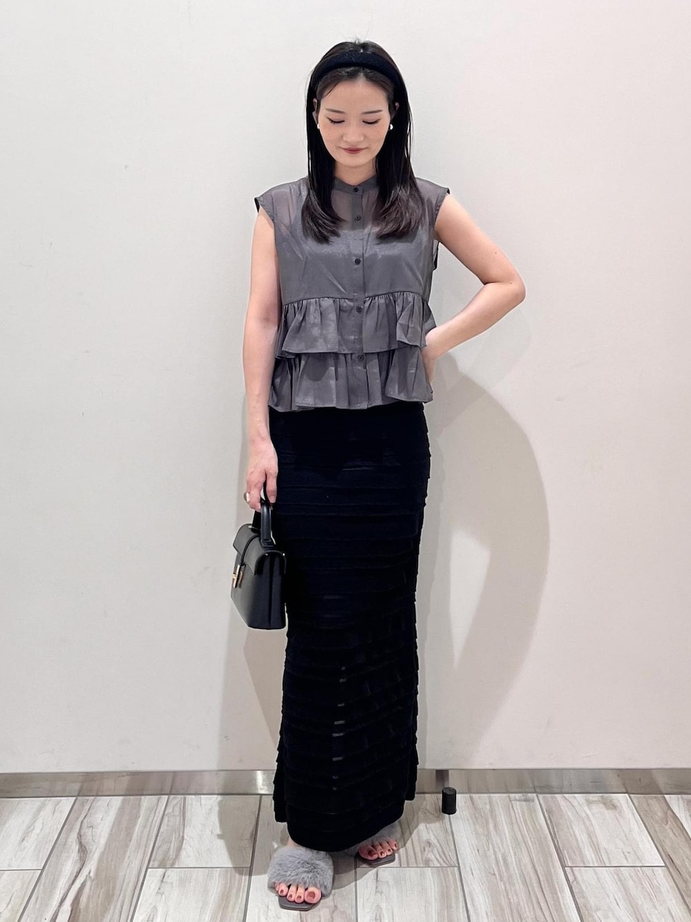 ブラック系のスカート、グレー系のシャツ/ブラウス、ブラック系のショルダーバッグを着用したレディースの夏コーディネートの1枚目の写真