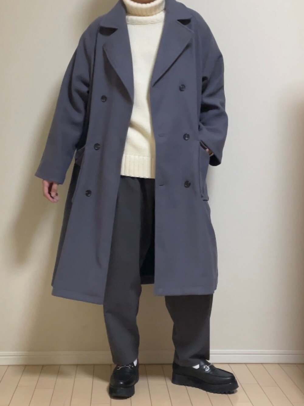 ブルー系のチェスターコート、グレー系のその他パンツ、ホワイト系のニット/セーターを着用したメンズの冬コーディネートの1枚目の写真