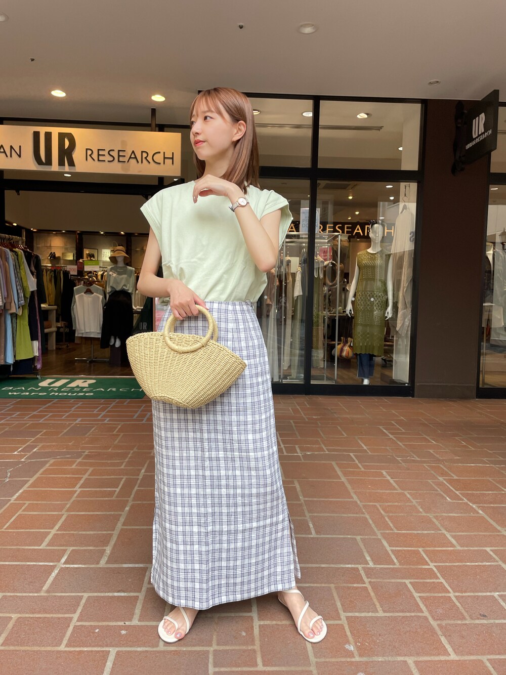 グリーン系のTシャツ/カットソー、ベージュ系のショルダーバッグ、グレー系のスカートを着用したレディースの夏コーディネートの1枚目の写真