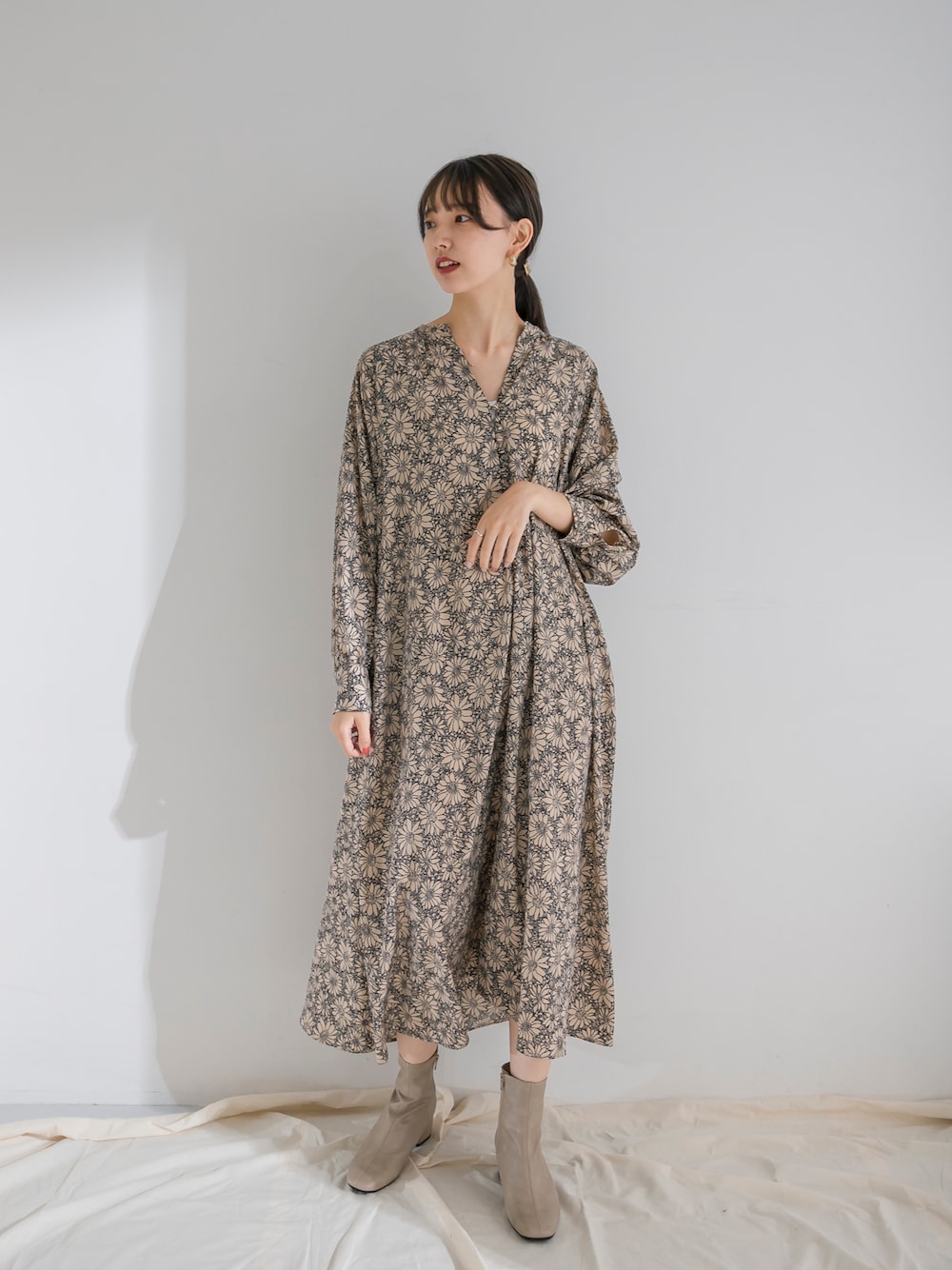 ベージュ系のワンピース、グレー系のブーツを着用したレディースの夏コーディネートの1枚目の写真