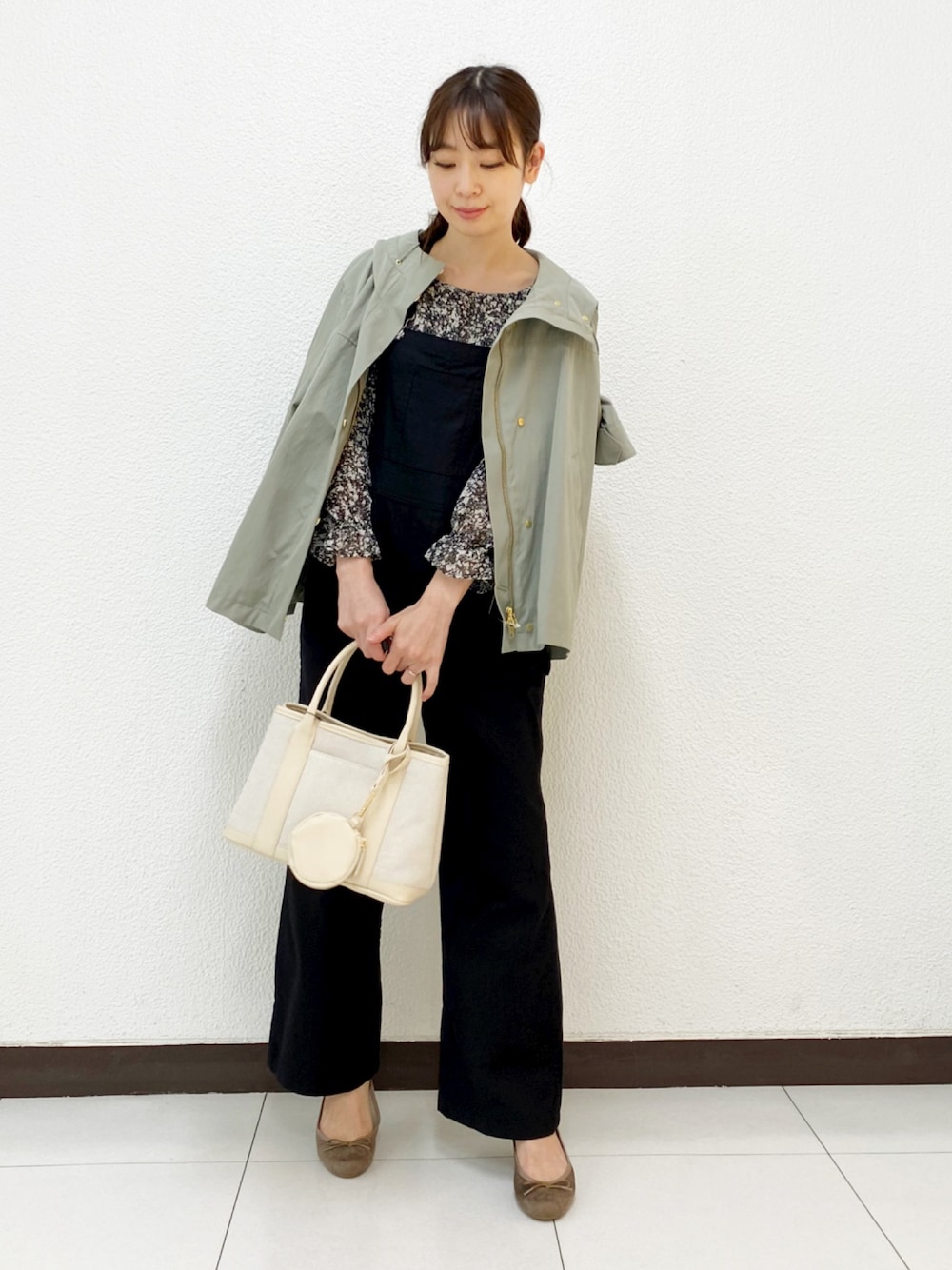 ベージュ系のトートバッグ、グリーン系のブルゾン、ブラック系のサロペット/オーバーオールを着用したレディースの春コーディネートの1枚目の写真