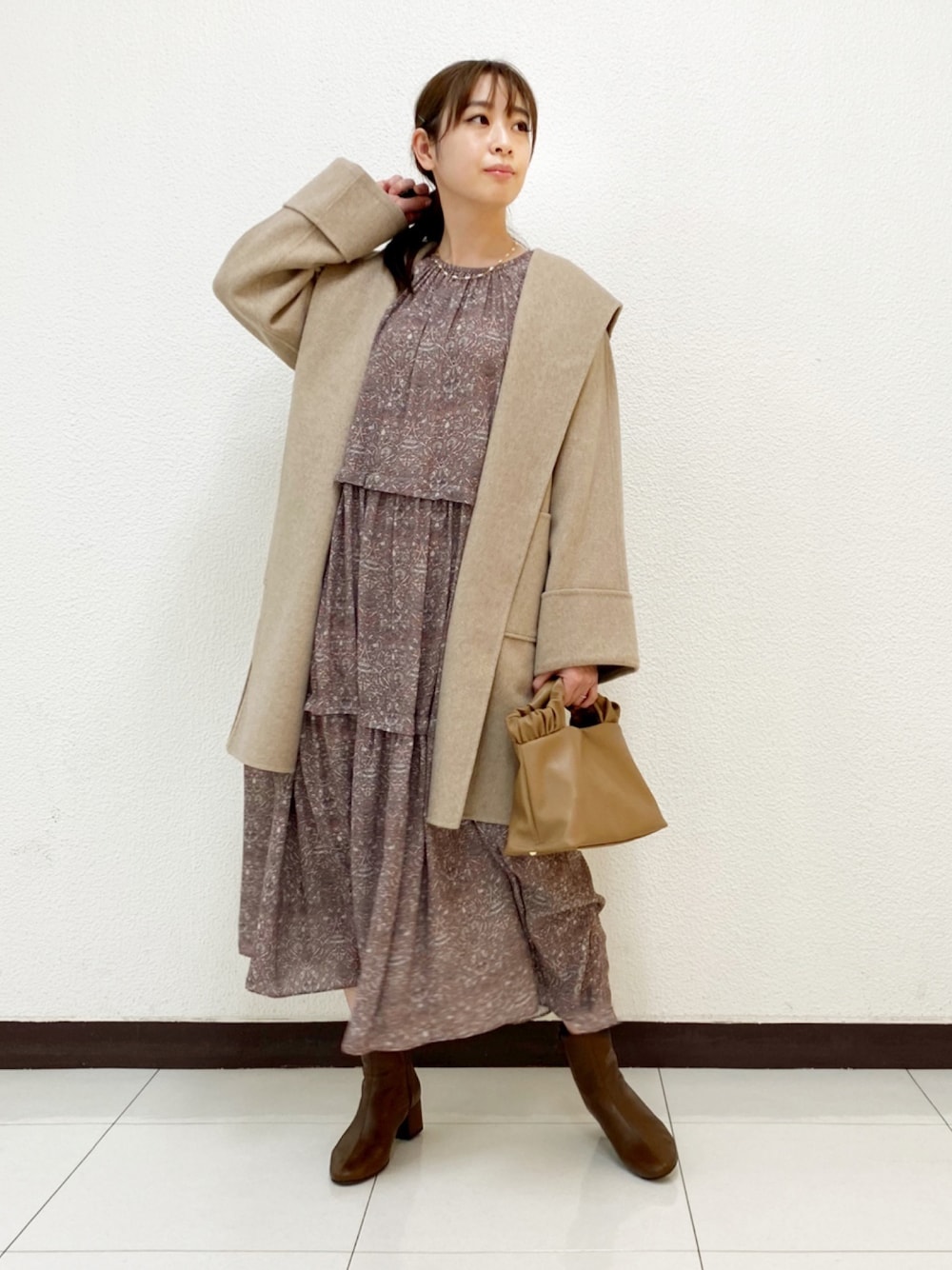 ベージュ系のバッグ、その他のワンピース、ベージュ系のその他アウターを着用したレディースの冬コーディネートの1枚目の写真