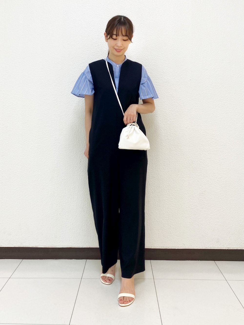 ブラック系のサロペット/オーバーオール、ホワイト系のサンダル、ブルー系のシャツ/ブラウスを着用したレディースの春コーディネートの1枚目の写真
