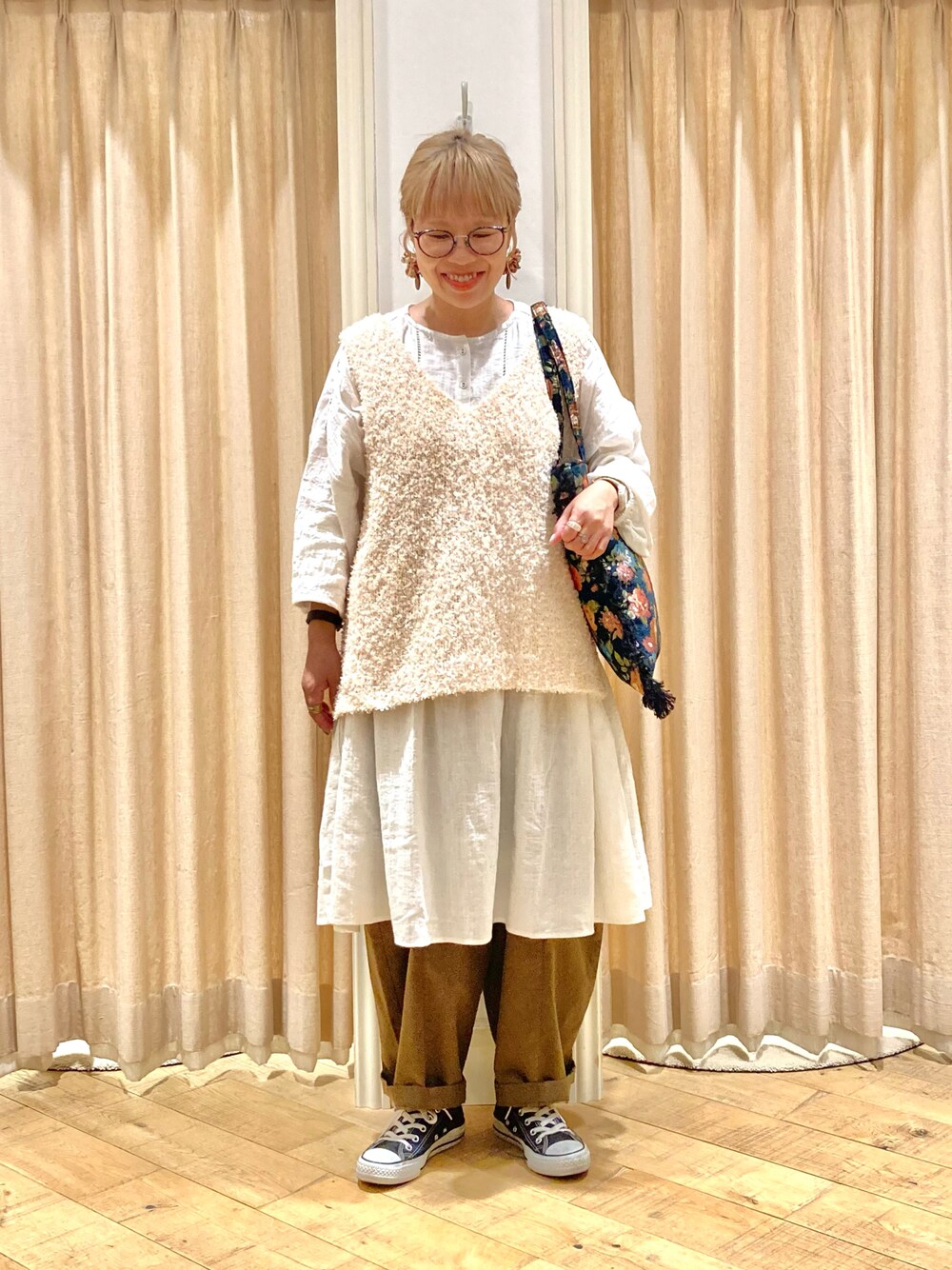 ホワイト系のチュニック、ホワイト系のベスト、グリーン系のその他パンツを着用したレディースの秋コーディネートの1枚目の写真
