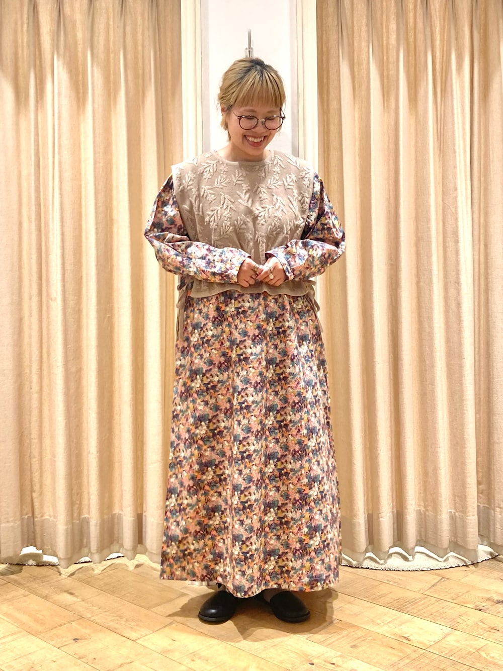 ピンク系のワンピース、ベージュ系のベスト、ブラック系のドレスシューズを着用したレディースの夏コーディネートの1枚目の写真