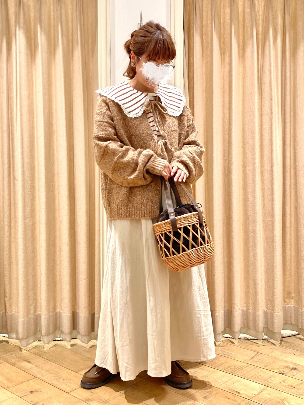 オレンジ系のカーディガン/ボレロ、ベージュ系のスカート、ベージュ系のTシャツ/カットソーを着用したレディースの秋コーディネートの1枚目の写真