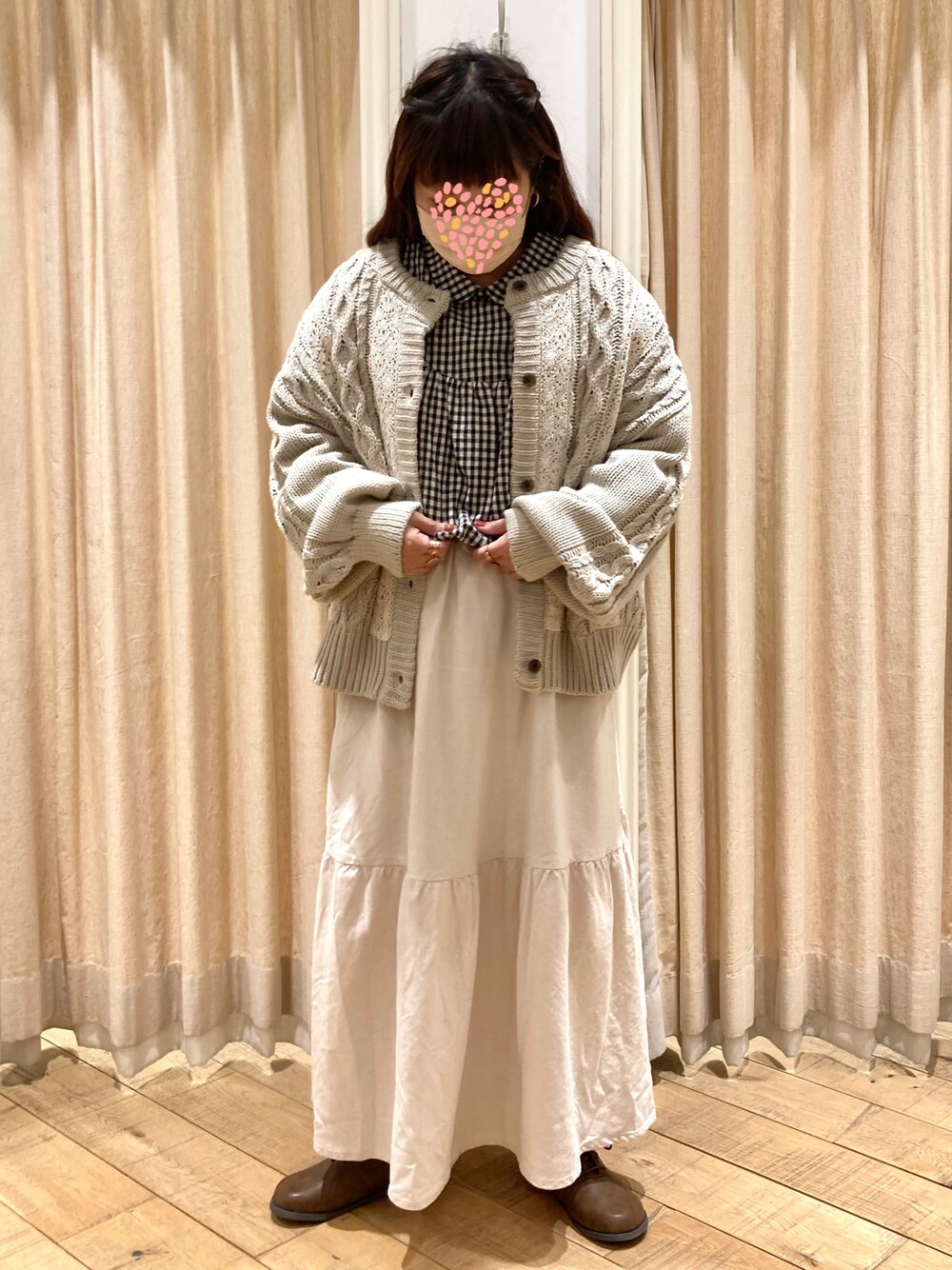 ブラック系のシャツ/ブラウス、ベージュ系のカーディガン/ボレロ、ホワイト系のスカートを着用したレディースの冬コーディネートの1枚目の写真