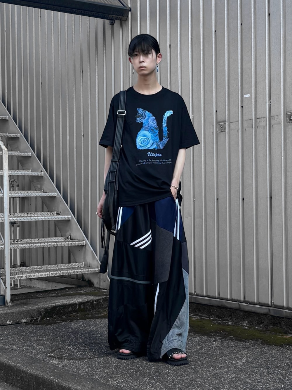 「Tシャツ、ロゴT、ブラック、トラックパンツ、ワイドパンツ、サンダル、ショルダーバッグ、レザー、夏コーデ、夏ファッション、ブルー、お出かけコーデ、モード、古着MIX、古着」｜「MAISON SPECIALの《ユニセックスアイテム》【SPECIAL SHOES FACTORY コラボ】東京産イタリアンビブラムソールタッセルサンダル【MAISON SPECIAL/メゾンスペシャル】（サンダル、ブラック系）」を使った、Uminaさん（骨格ウェーブ・メンズ・170cm）の夏コーディネートの1枚目の写真