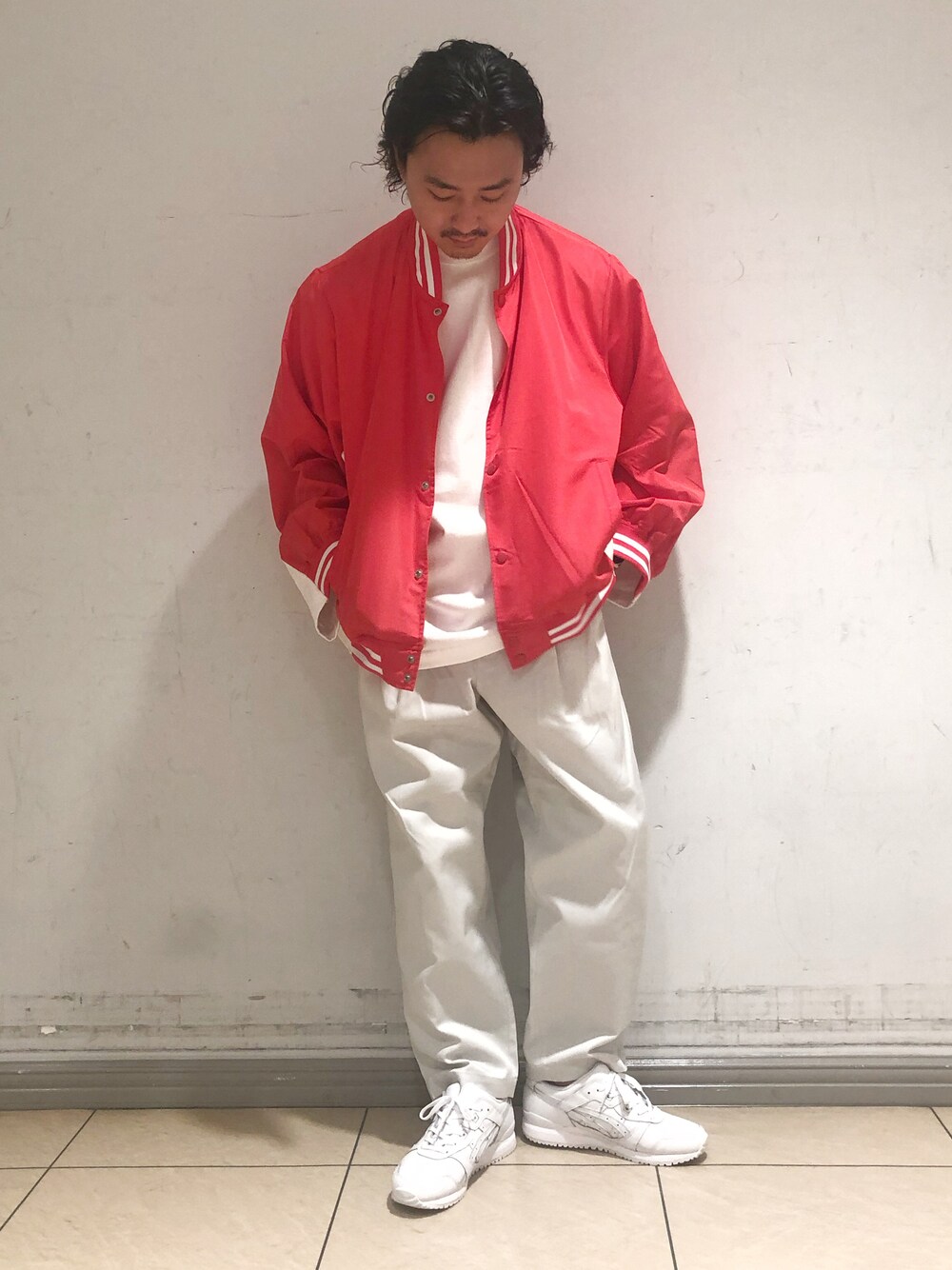 ホワイト系のチノパンツ、ホワイト系のスニーカー、レッド系のスタジャンを着用したメンズの秋コーディネートの1枚目の写真