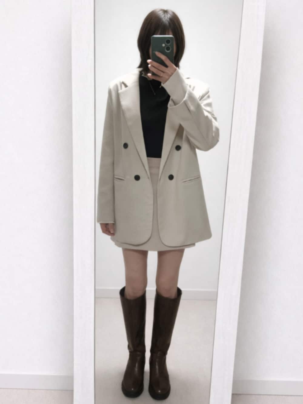 ホワイト系のテーラードジャケット、グレー系のTシャツ/カットソー、ベージュ系のスカートを着用したレディースの春コーディネートの1枚目の写真