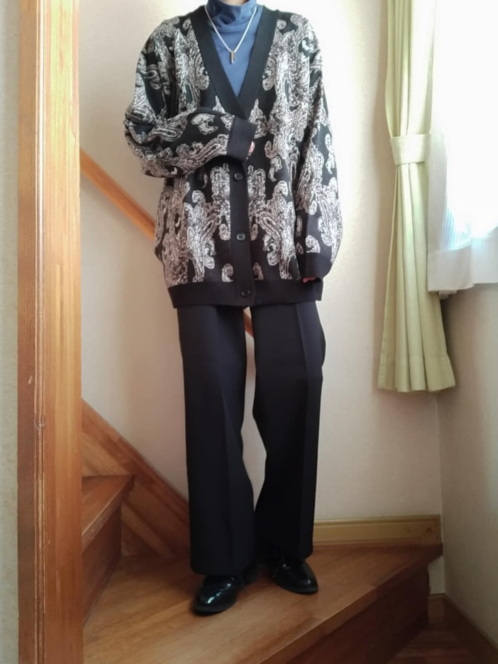 ブラック系のカーディガン/ボレロ、ブラック系のスラックス、シルバー系のネックレスを着用したレディースの秋コーディネートの1枚目の写真