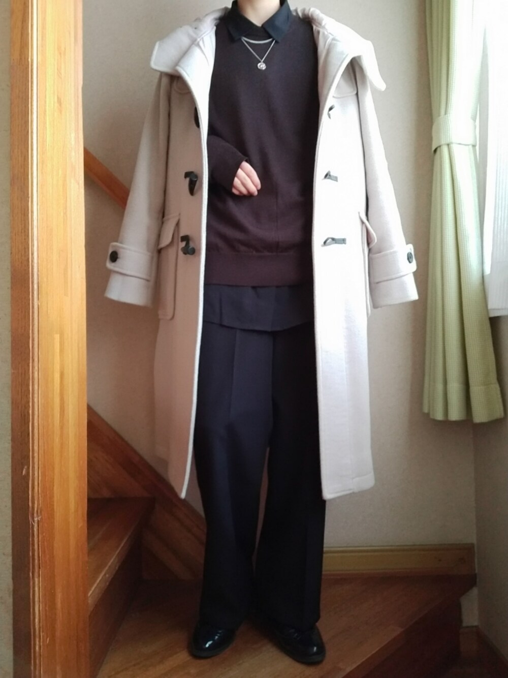 ブラック系のシャツ/ブラウス、ブラック系のスラックス、ブラウン系のニット/セーターを着用したレディースの冬コーディネートの1枚目の写真