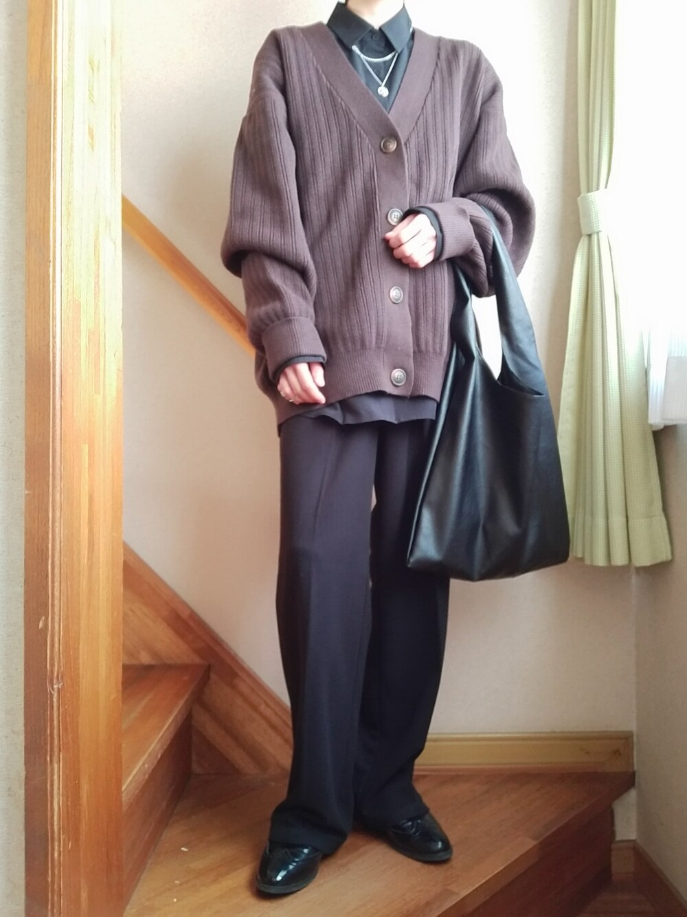 ブラウン系のカーディガン/ボレロ、ブラック系のシャツ/ブラウス、ブラック系のスラックスを着用したレディースの冬コーディネートの2枚目の写真