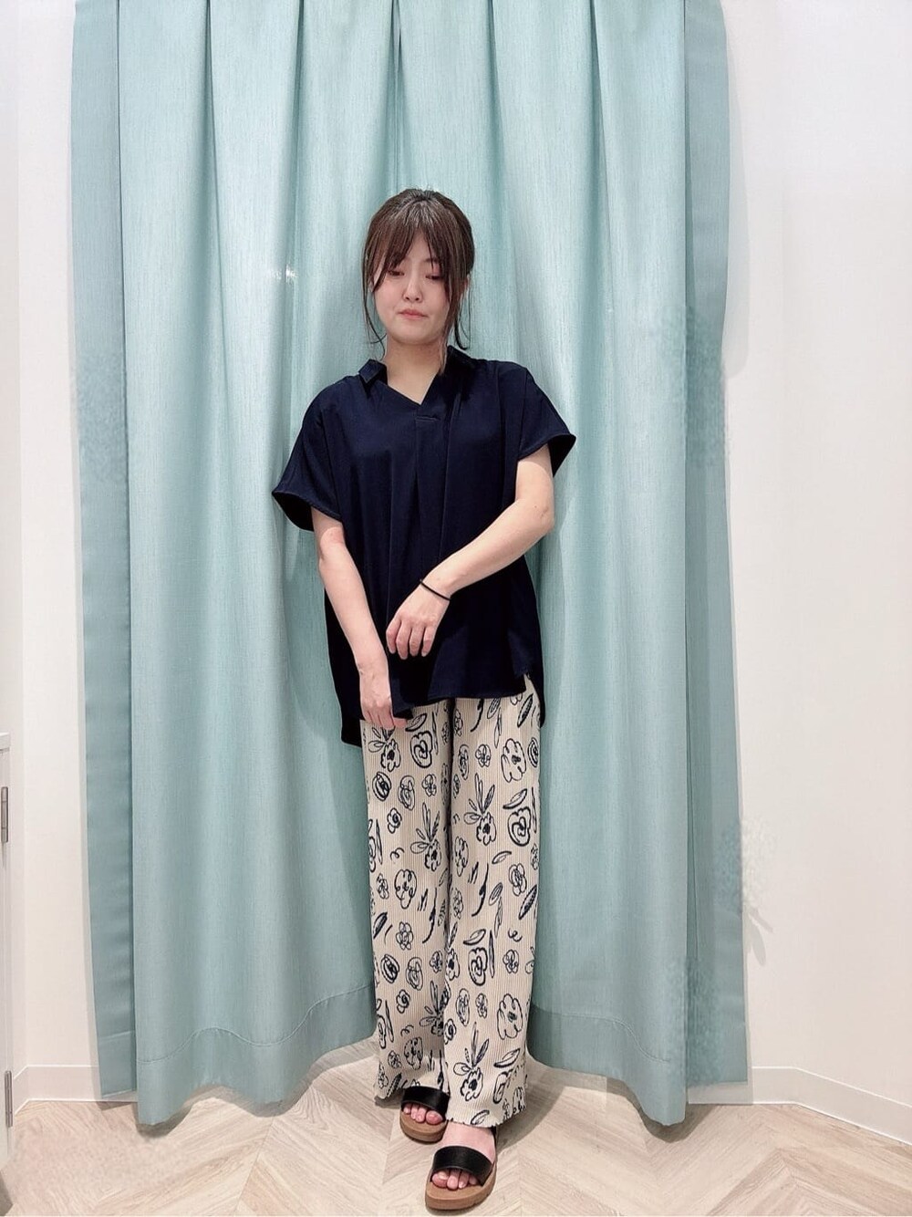 ベージュ系のその他パンツ、ブラック系のサンダル、ブルー系のショルダーバッグを着用したレディースの夏コーディネートの1枚目の写真
