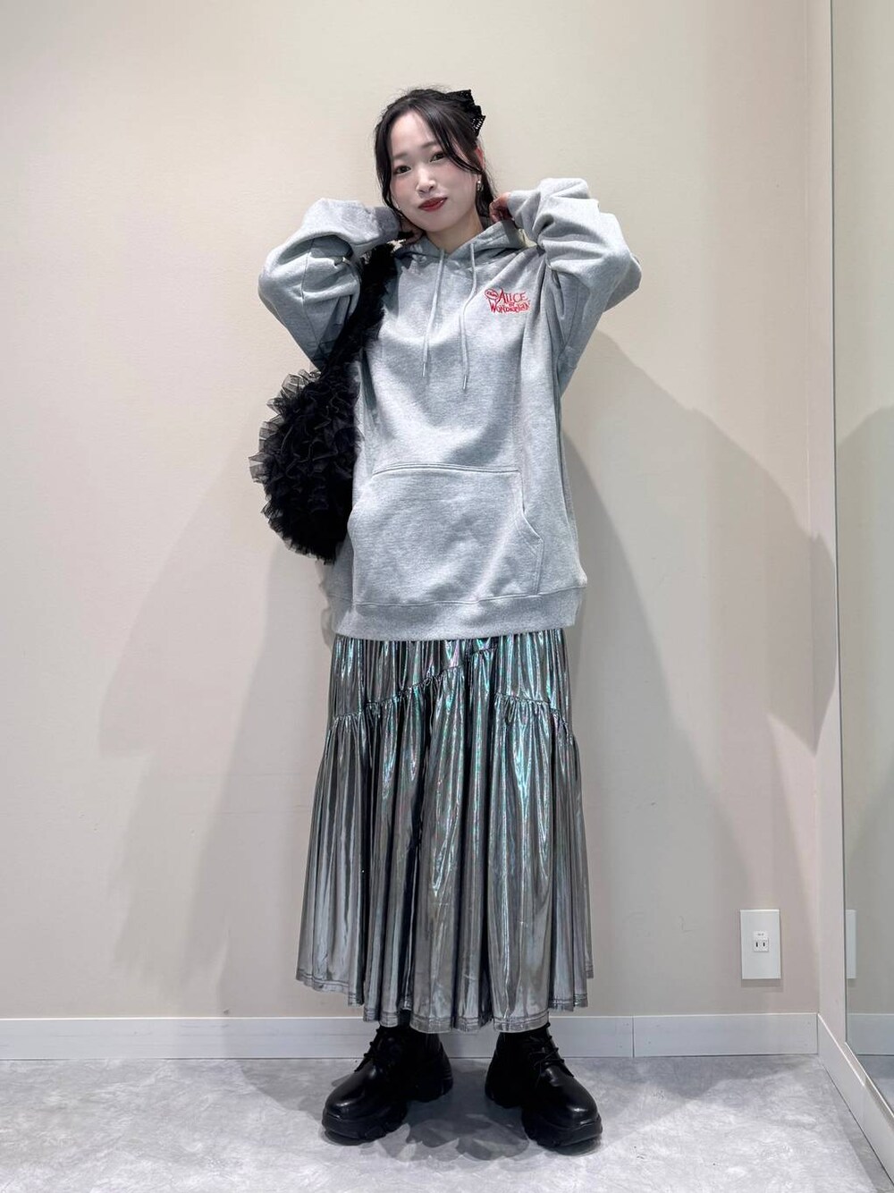 グレー系のスカート、グレー系のスウェット、ブラック系のショルダーバッグを着用したレディースの秋コーディネートの1枚目の写真