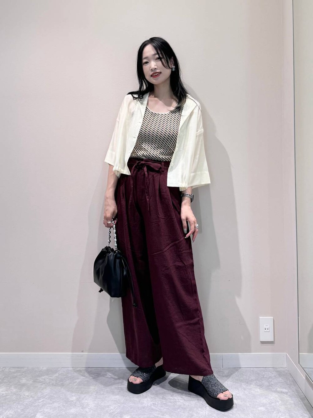 ホワイト系のシャツ/ブラウス、ホワイト系のTシャツ/カットソー、ブラック系のショルダーバッグを着用したレディースの夏コーディネートの1枚目の写真
