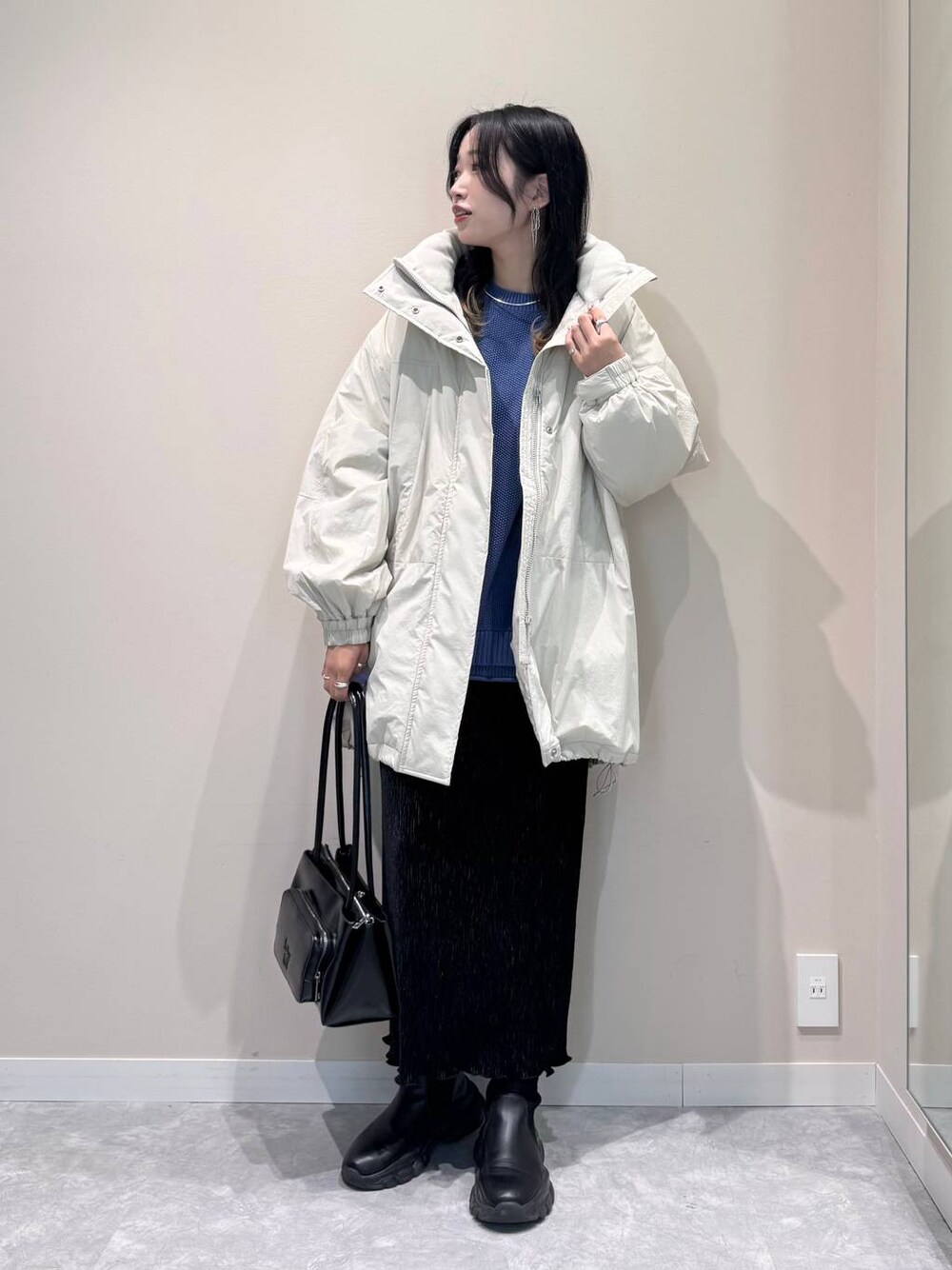 ホワイト系のその他アウター、ブルー系のニット/セーター、ブラック系のショルダーバッグを着用したレディースの冬コーディネートの1枚目の写真