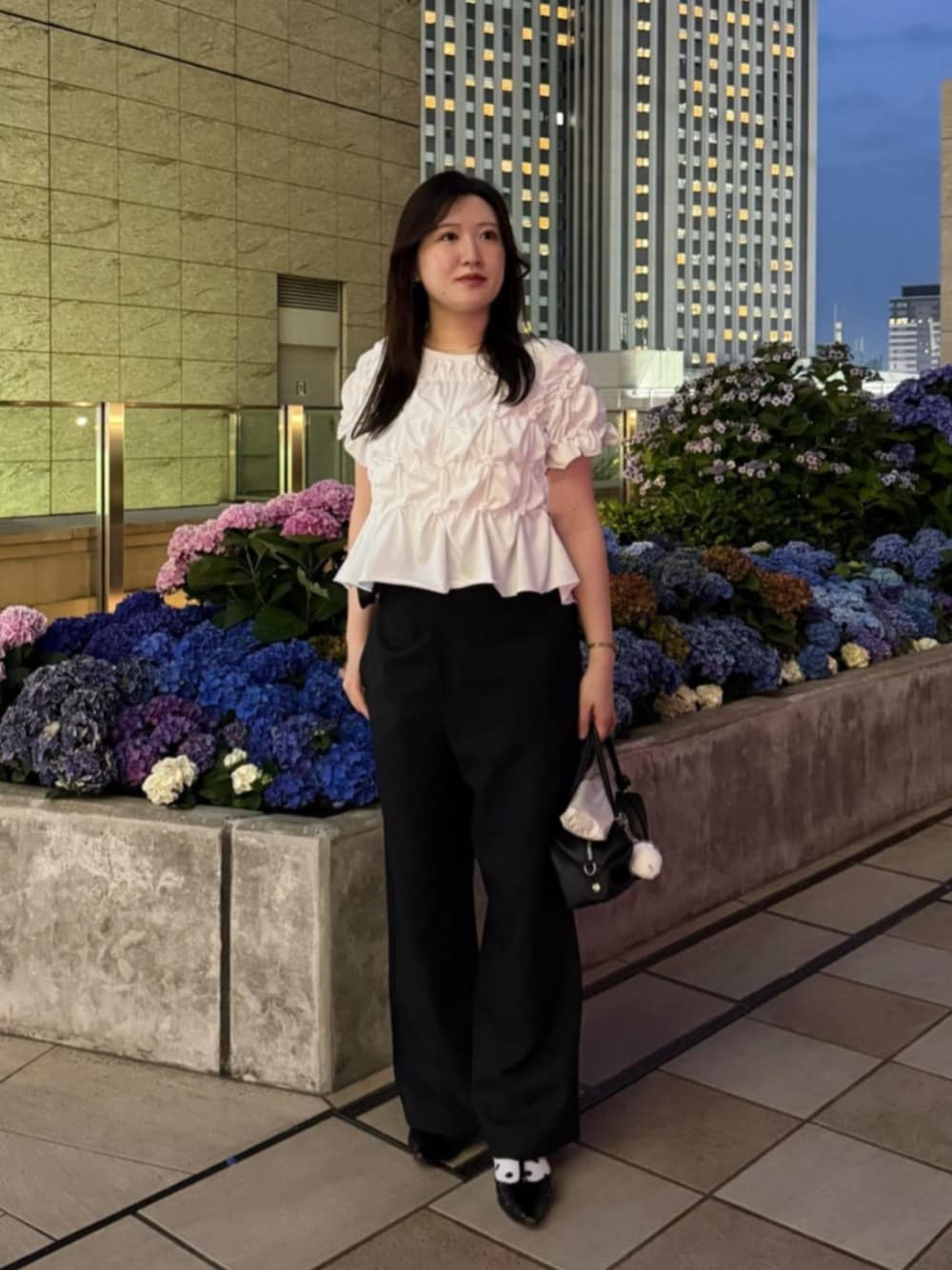 ブラック系のその他パンツ、ブラック系のパンプス、ホワイト系のTシャツ/カットソーを着用したレディースの夏コーディネートの1枚目の写真