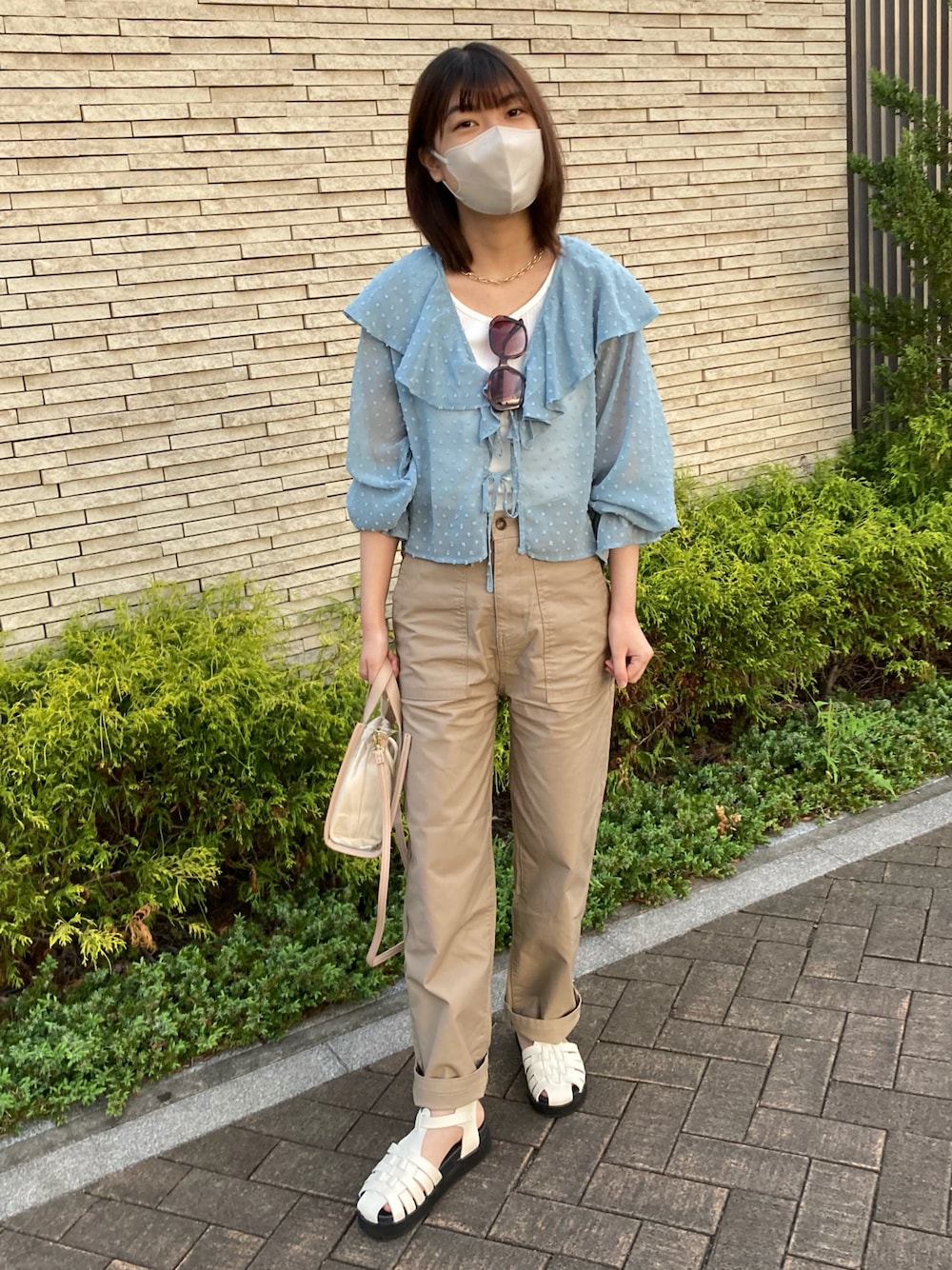 ブルー系のシャツ/ブラウス、ホワイト系のサンダル、ベージュ系のバッグを着用したレディースの春コーディネートの1枚目の写真