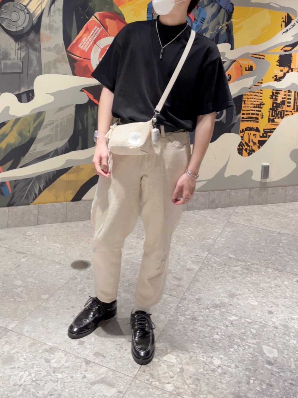 ブラック系のシューズ、ベージュ系のデニムパンツ、ホワイト系のショルダーバッグを着用したメンズの春コーディネートの1枚目の写真