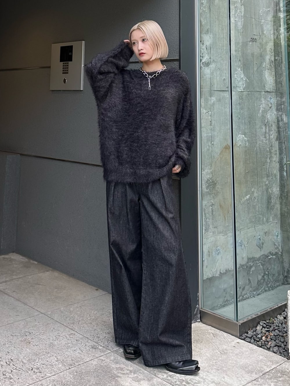 ブラック系のニット/セーター、ブラック系のデニムパンツ、シルバー系のネックレスを着用したレディースの秋コーディネートの1枚目の写真