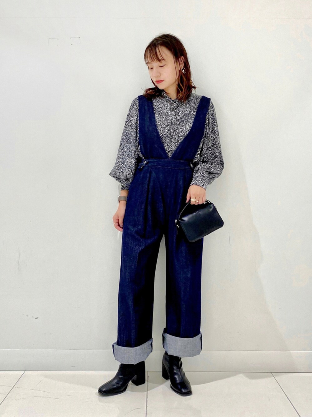 ブラック系のシャツ/ブラウス、ブルー系のサロペット/オーバーオール、ブラック系のショルダーバッグを着用したレディースの秋コーディネートの1枚目の写真