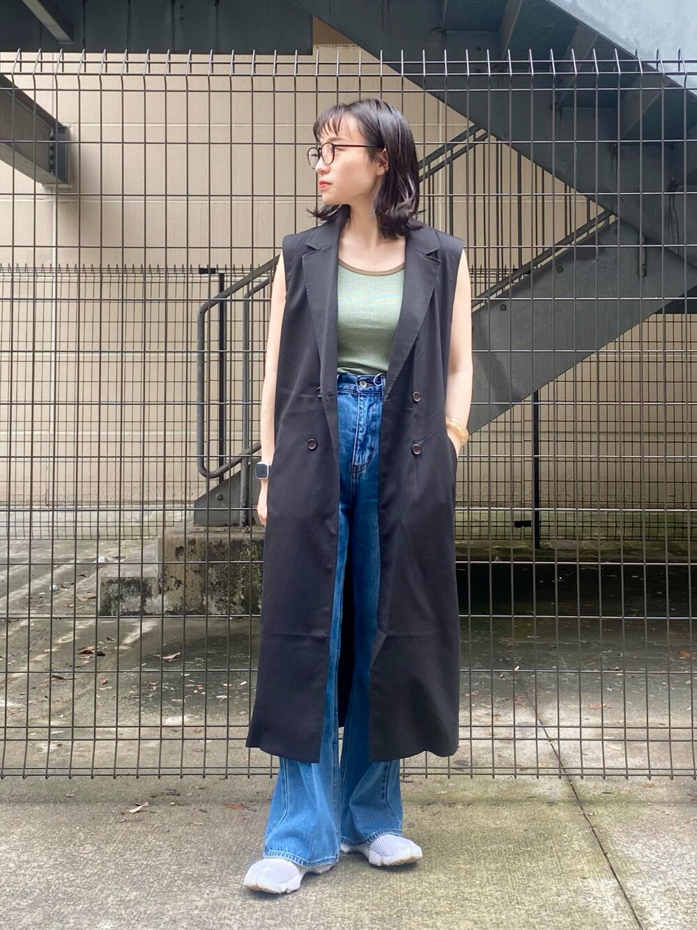 グリーン系のタンクトップ、ブルー系のデニムパンツ、ホワイト系のシューズを着用したレディースの夏コーディネートの1枚目の写真