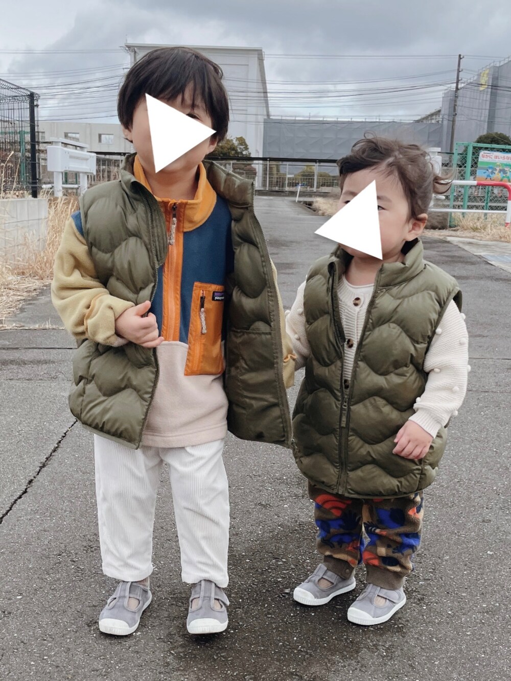 グリーン系のダウンベスト、グリーン系のダウンベスト、ホワイト系のニット/セーターを着用したキッズの春コーディネートの1枚目の写真