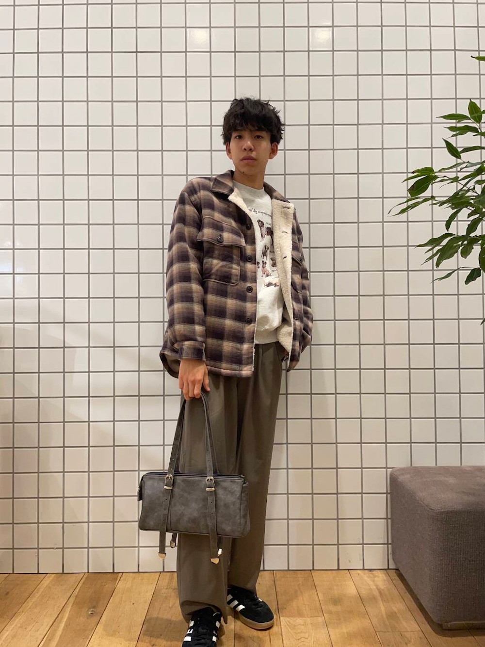 グレー系のボストンバッグ、ブラウン系のその他アウター、グレー系のスウェットを着用したメンズの冬コーディネートの1枚目の写真