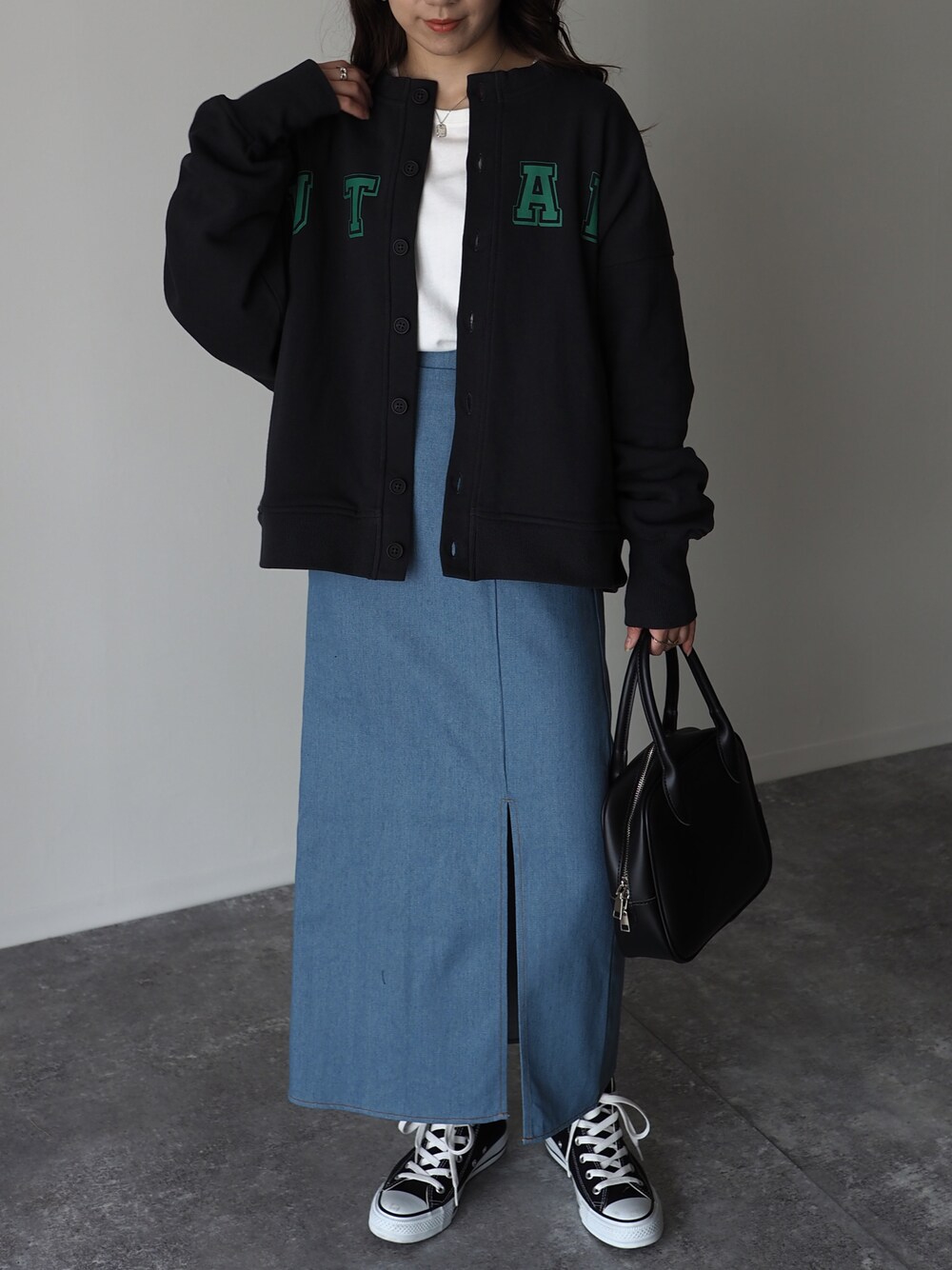 ホワイト系のTシャツ/カットソー、ブルー系のデニムスカート、ブラック系のショルダーバッグを着用したレディースの冬コーディネートの1枚目の写真