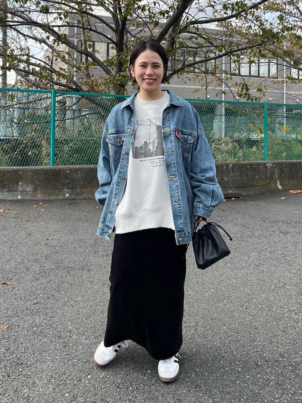 ベージュ系のスウェット、ブラック系のスカート、ホワイト系のスニーカーを着用したレディースの秋コーディネートの1枚目の写真