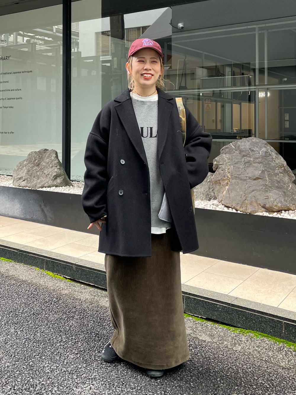 グリーン系のスカート、ホワイト系のTシャツ/カットソー、ブラック系のTシャツ/カットソーを着用したレディースの秋コーディネートの1枚目の写真