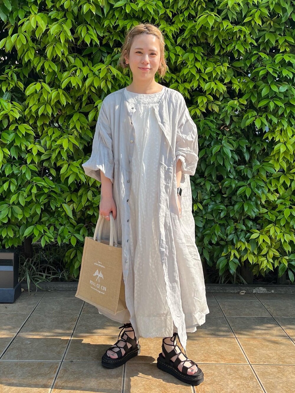 ホワイト系のワンピース、グレー系のワンピース、ブラック系のサンダルを着用したレディースの春コーディネートの1枚目の写真