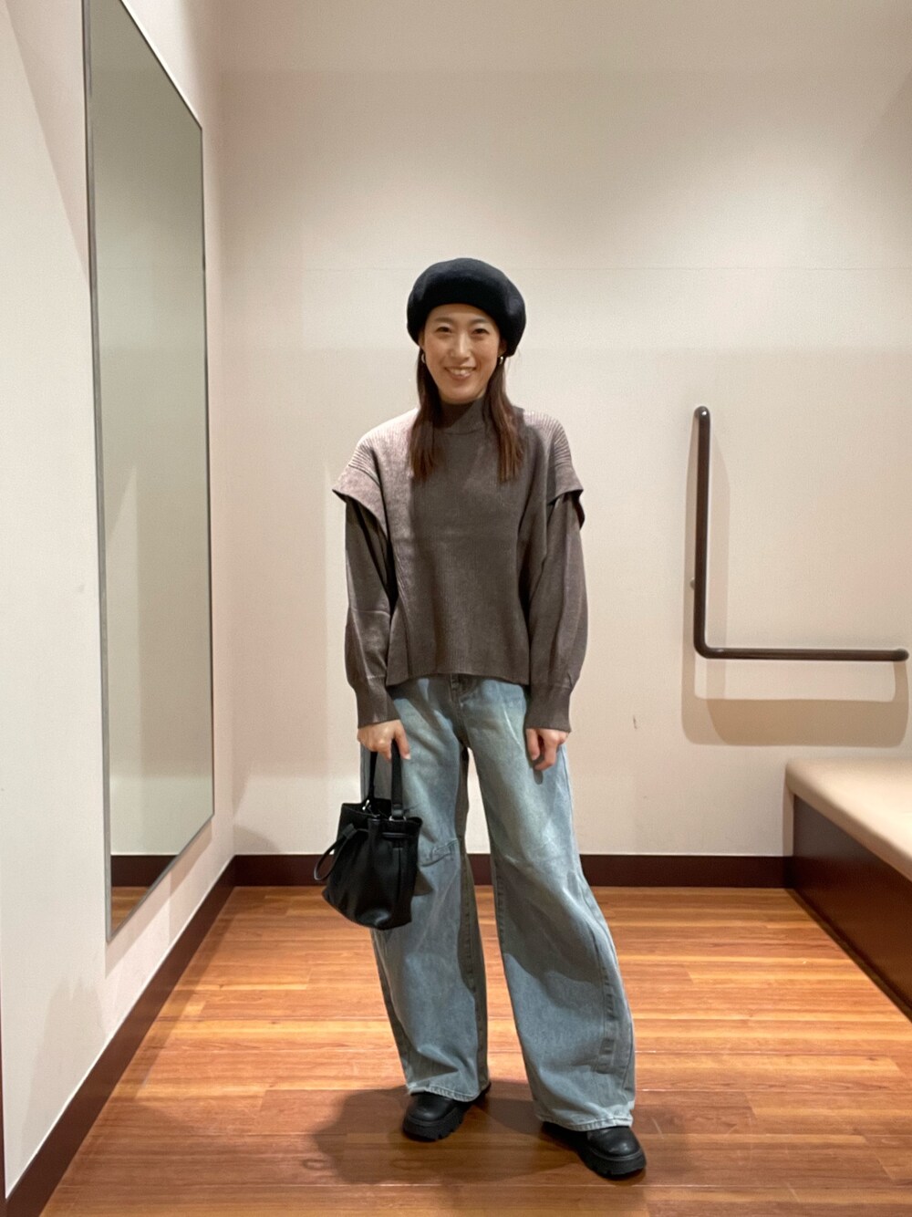 ブラウン系のニット/セーター、ブルー系のデニムパンツ、ブラック系のショルダーバッグを着用したレディースの冬コーディネートの1枚目の写真
