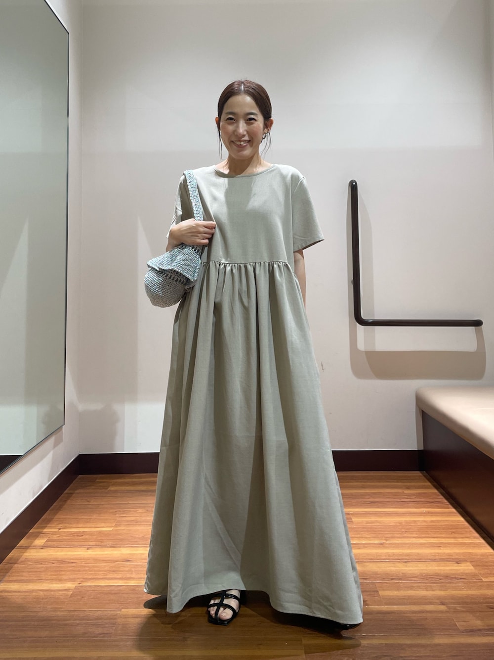 ベージュ系のワンピース、シルバー系のショルダーバッグ、ブラック系のサンダルを着用したレディースの夏コーディネートの1枚目の写真