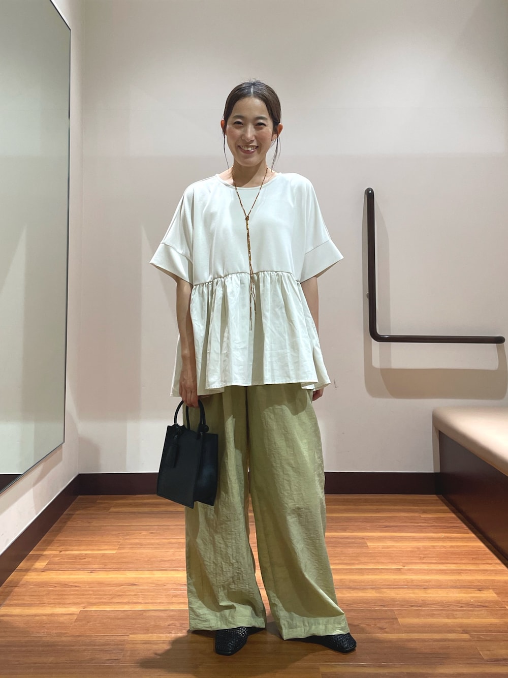 ホワイト系のTシャツ/カットソー、ブラック系のハンドバッグ、ブラック系のバレエシューズを着用したレディースの春コーディネートの1枚目の写真