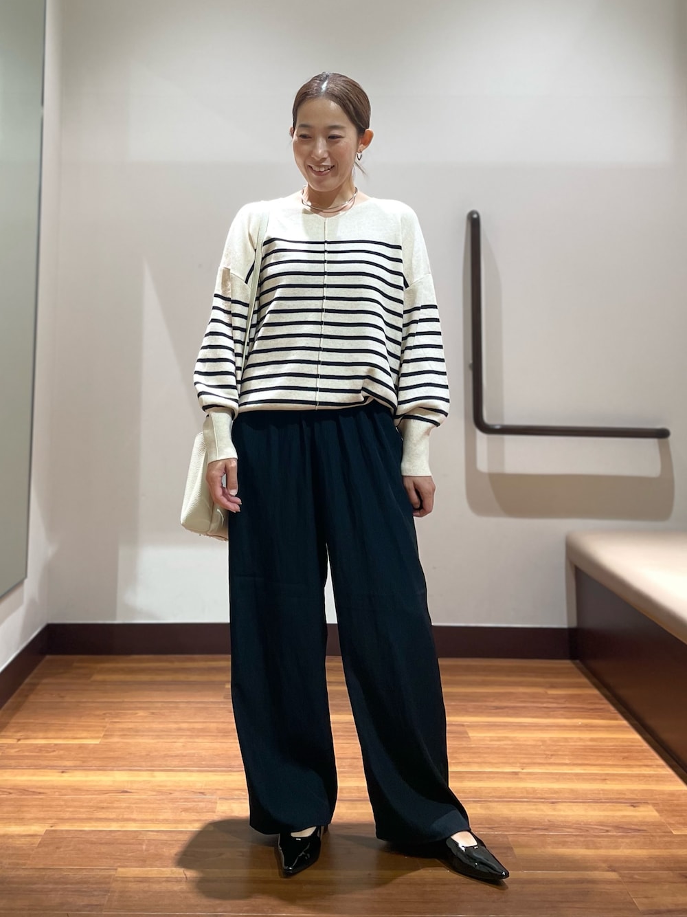 ブラック系のパンプス、ホワイト系のショルダーバッグ、ホワイト系のニット/セーターを着用したレディースの秋コーディネートの1枚目の写真