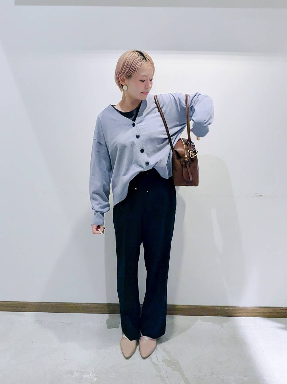 ベージュ系のパンプス、ブラウン系のボストンバッグ、ブルー系のカーディガン/ボレロを着用したレディースの秋コーディネートの1枚目の写真