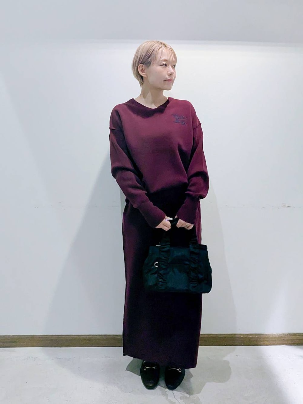 ブラウン系のローファー、ブラック系のショルダーバッグ、レッド系のニット/セーターを着用したレディースの秋コーディネートの1枚目の写真