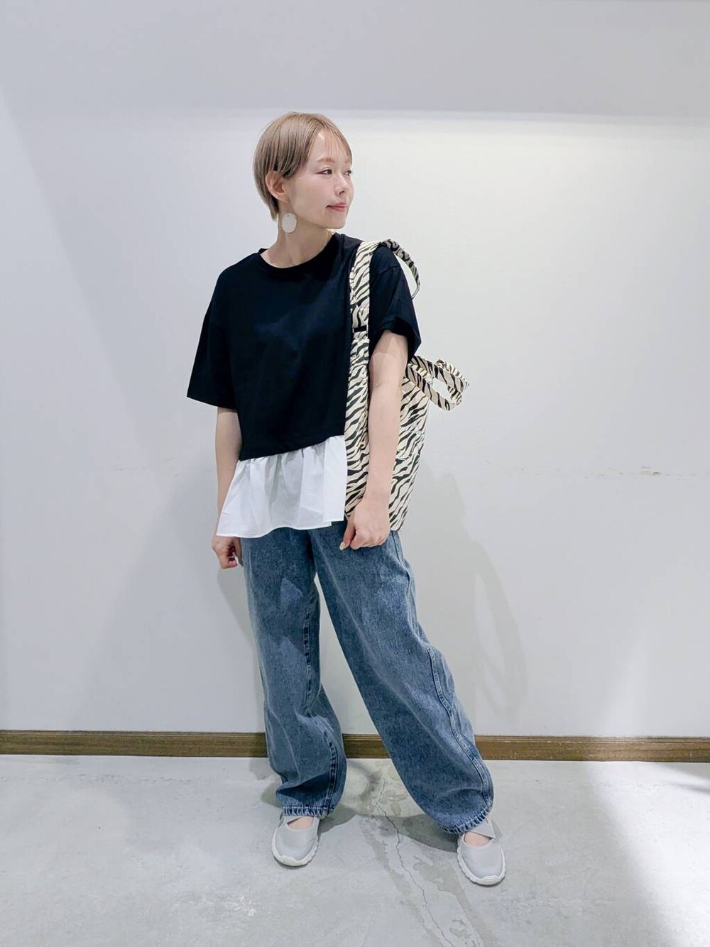 グレー系のスニーカー、その他のトートバッグ、ブルー系のデニムパンツを着用したレディースの夏コーディネートの1枚目の写真