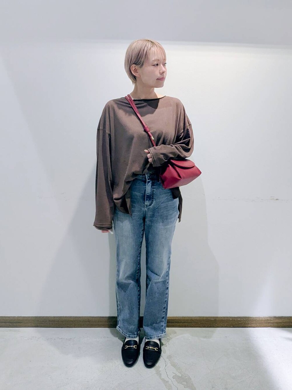 ブラウン系のローファー、ブラック系のキャミソール、ブルー系のデニムパンツを着用したレディースの秋コーディネートの1枚目の写真