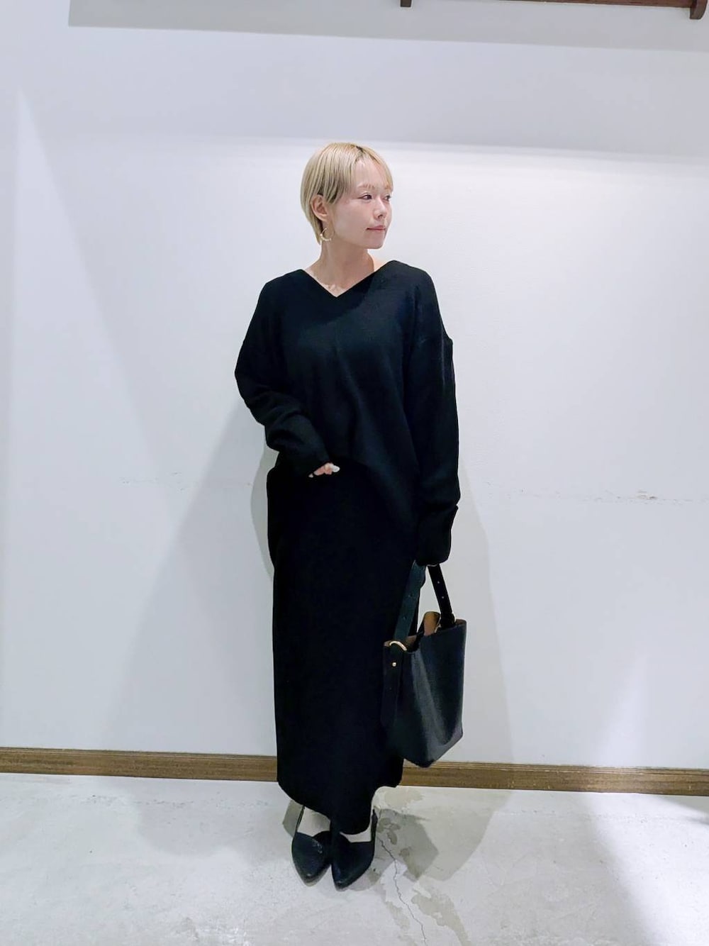 ブラック系のショルダーバッグ、ブラック系のパンプス、ブラック系のキャミソールを着用したレディースの冬コーディネートの1枚目の写真