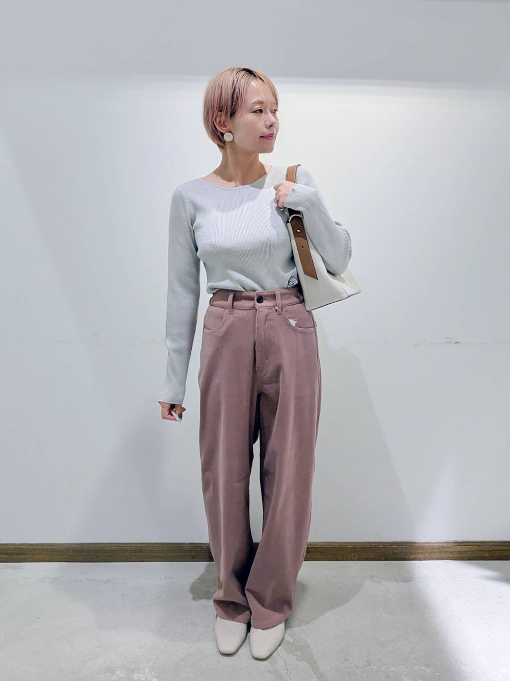 ベージュ系のパンプス、ホワイト系のショルダーバッグ、ベージュ系のニット/セーターを着用したレディースの秋コーディネートの1枚目の写真