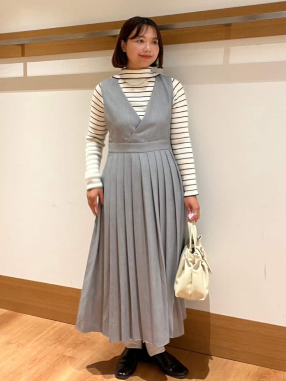 ベージュ系のトートバッグ、ホワイト系のニット/セーター、グレー系のワンピースを着用したレディースの秋コーディネートの1枚目の写真