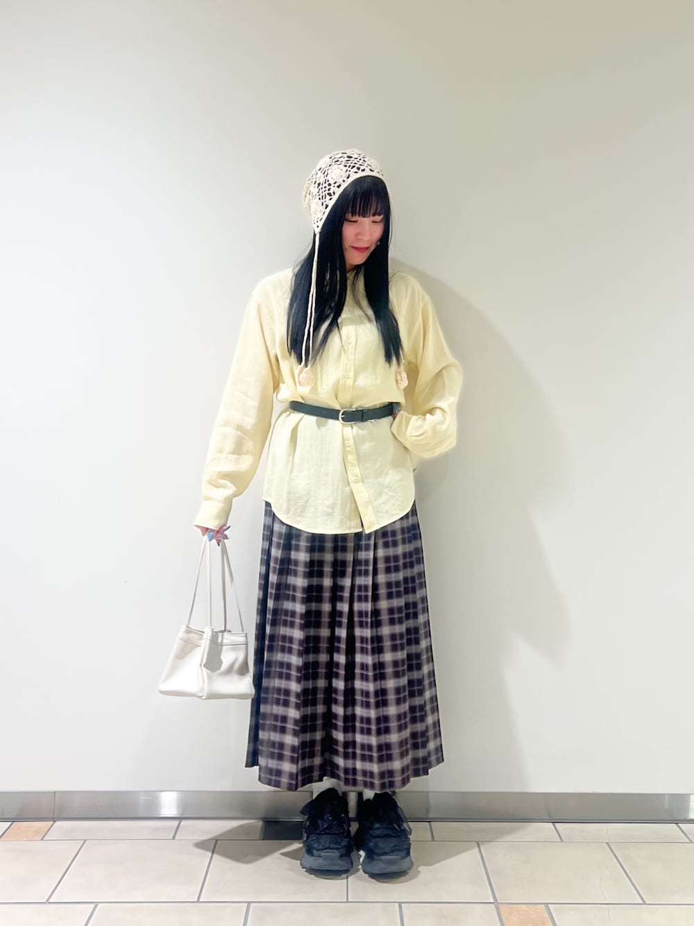 ホワイト系のハンドバッグ、イエロー系のシャツ/ブラウス、ブルー系のスカートを着用したレディースの春コーディネートの1枚目の写真