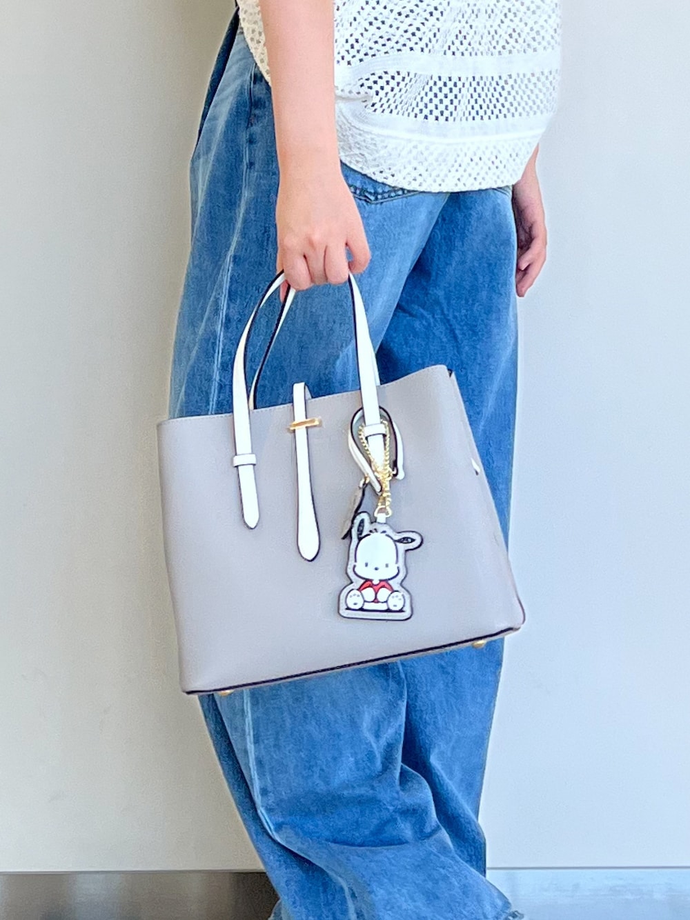 グレー系のハンドバッグ、ブルー系のデニムパンツ、ホワイト系のその他トップスを着用したレディースの夏コーディネートの1枚目の写真