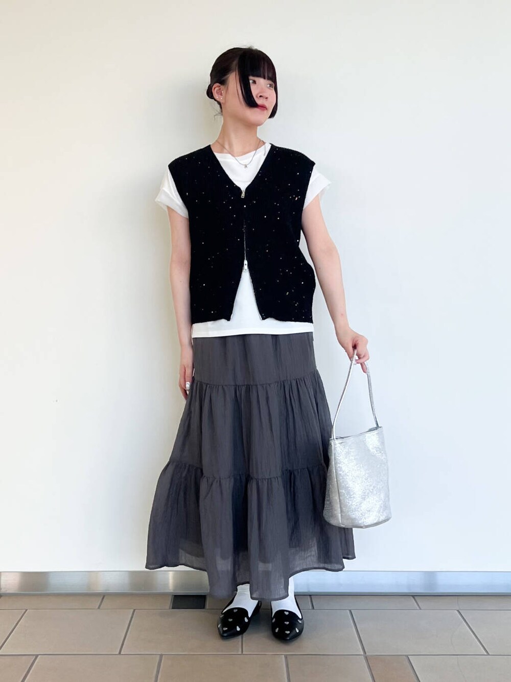 ブラック系のパンプス、シルバー系のハンドバッグ、ホワイト系のTシャツ/カットソーを着用したレディースの夏コーディネートの1枚目の写真