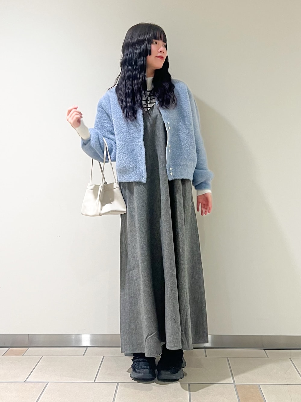 ブラック系のワンピース、ブルー系のカーディガン/ボレロ、ホワイト系のニット/セーターを着用したレディースの秋コーディネートの1枚目の写真